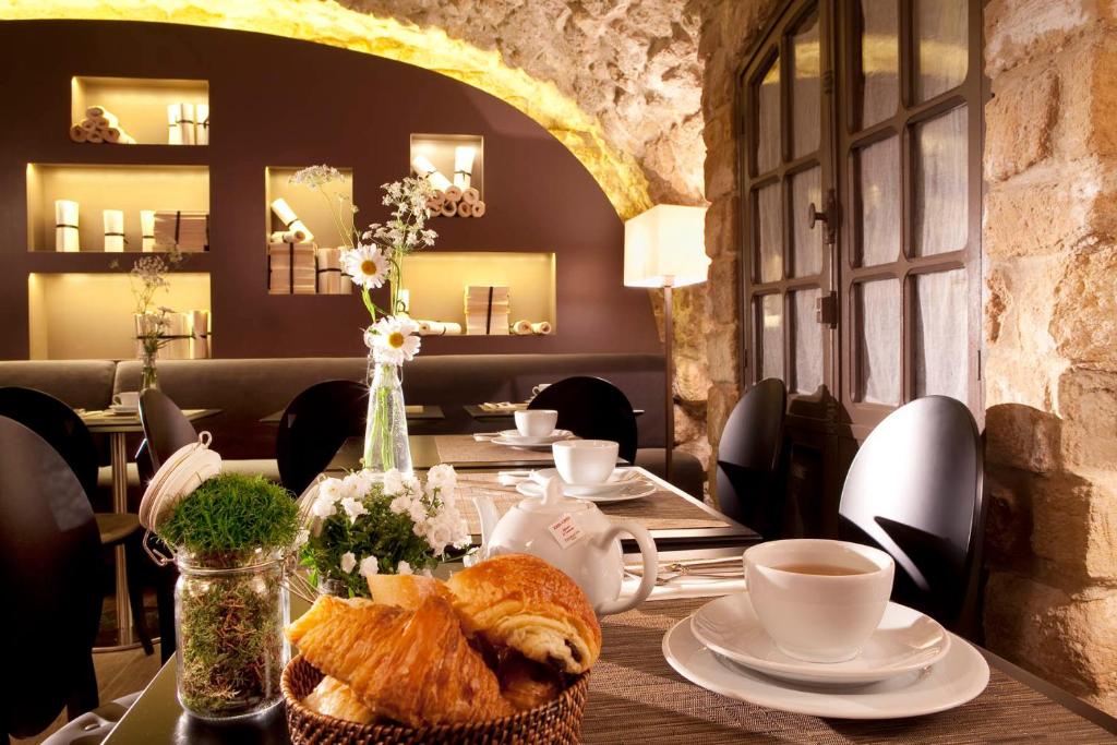 a table with bread and a cup of coffee on it at Hotel Verneuil Saint Germain in Paris