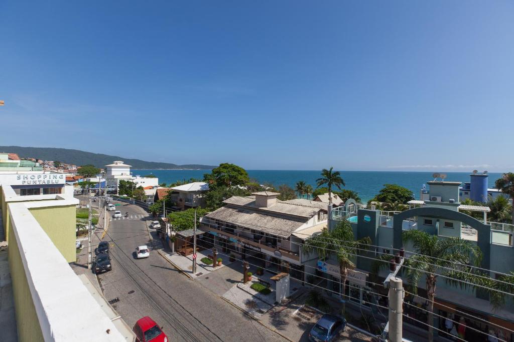 a city street with buildings and the ocean in the background at Pousada Brisa do Mar in Bombinhas
