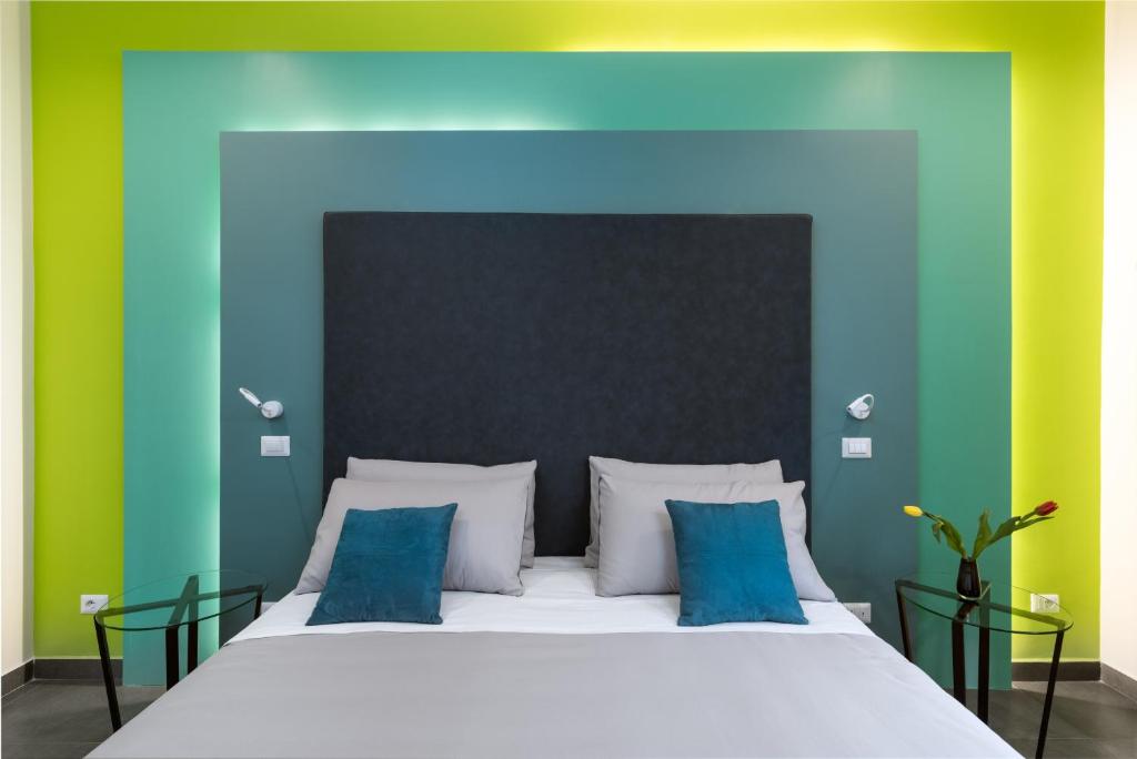 Schlafzimmer mit einem Bett mit blauen und grünen Wänden in der Unterkunft Circle in the Square in Rom