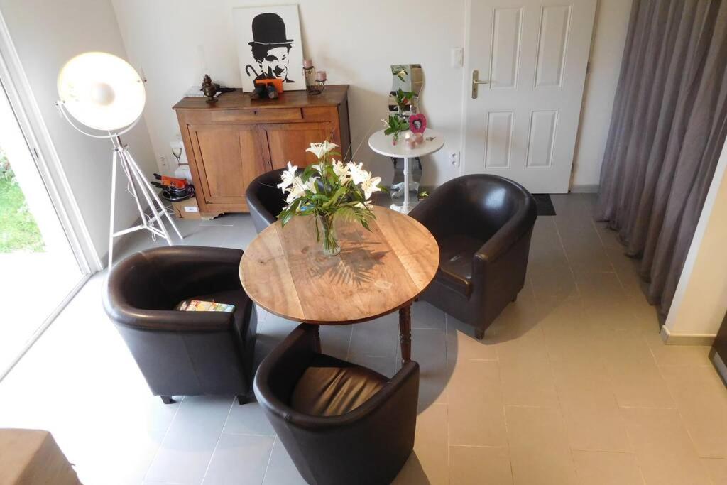 - un salon avec une table et des fauteuils en cuir dans l'établissement Le pigeonnier, à Chouzy-sur-Cisse