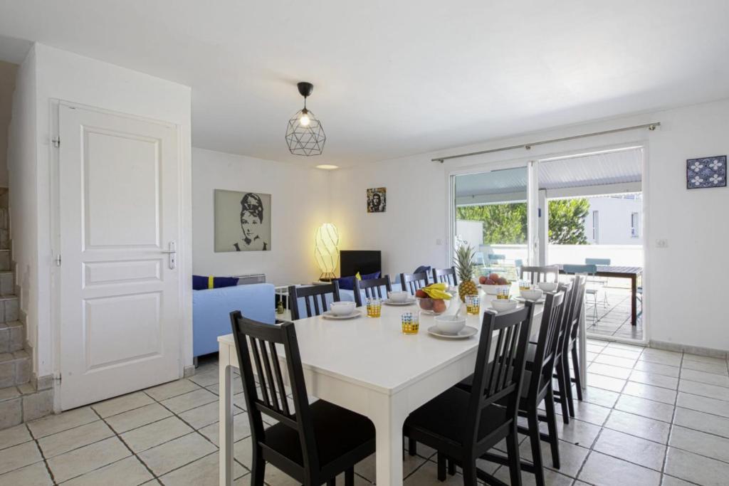uma sala de jantar com uma mesa branca e cadeiras em Superb triplex with panoramic terrace - Bayonne - Welkeys em Baiona