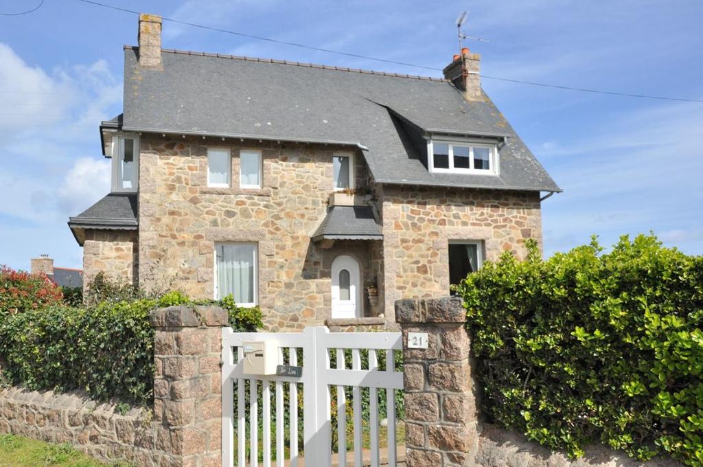 een stenen huis met een wit hek bij Maison bretonne à 200m de la mer à proximité de l'Ile Renote à Trégastel - Ref 76 in Trégastel