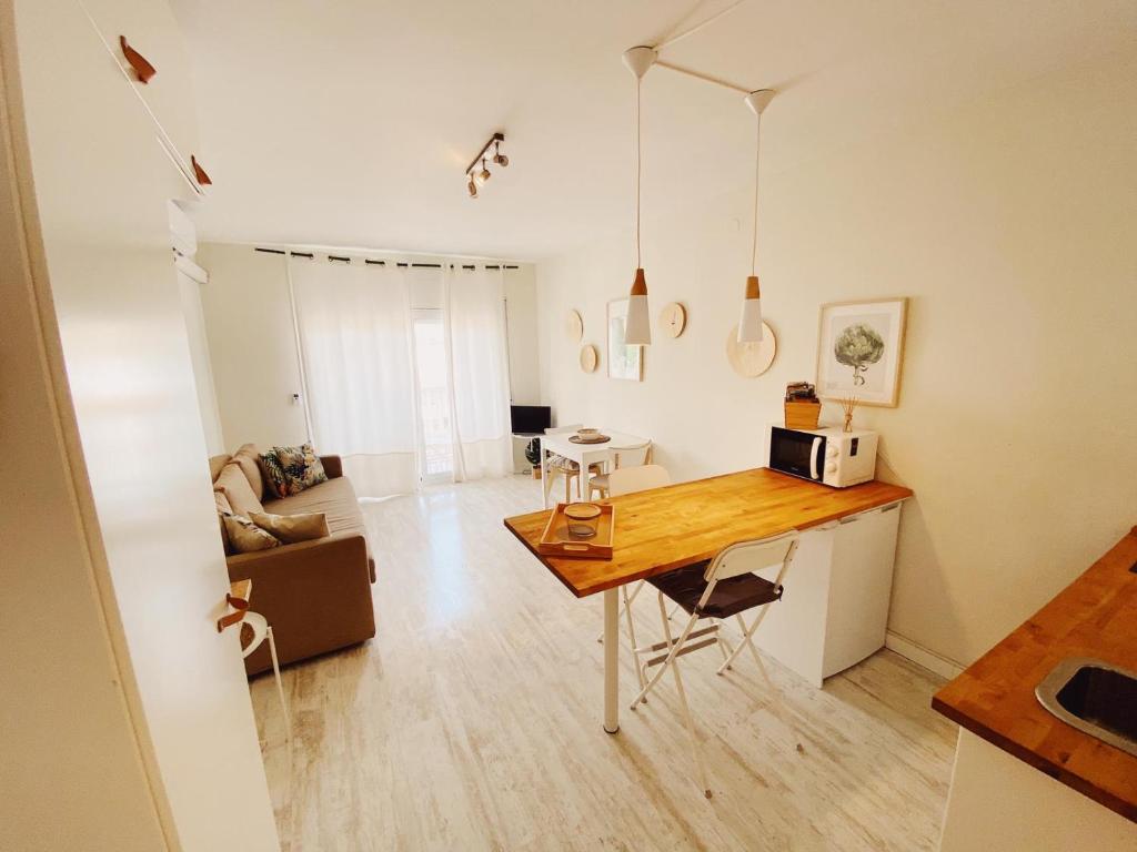 a kitchen and living room with a table in a room at Tropical Apartaments Euroviajeros in Pineda de Mar
