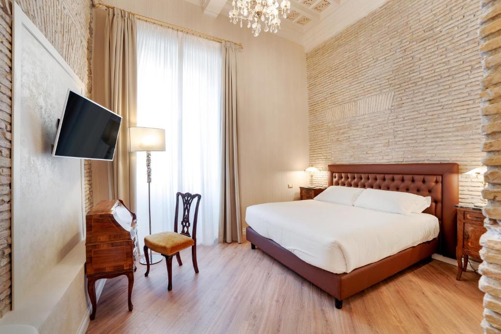 a bedroom with a bed and a tv and a chair at Pantheon Hedonism in Rome