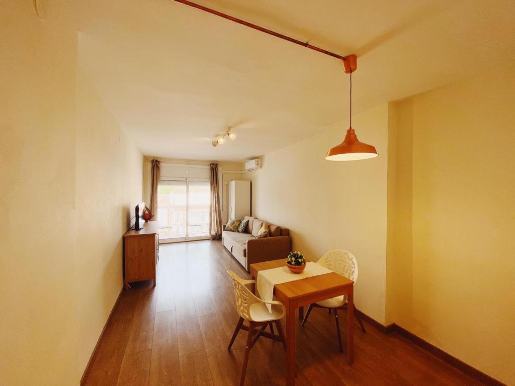 sala de estar con mesa, sillas y sofá en Arena Gold Euroviajeros apartaments, en Pineda de Mar