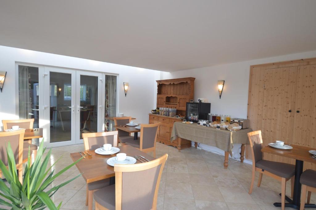 a living room with a piano and tables and chairs at Lakeside Old Hunstanton in Hunstanton