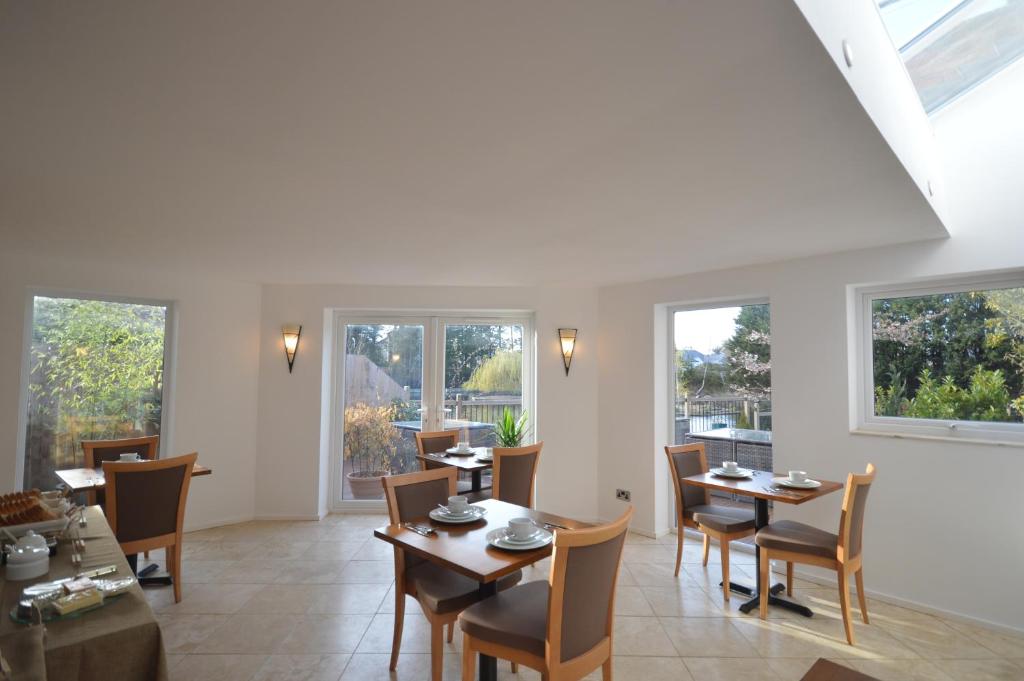 a dining room with tables and chairs and windows at Lakeside Old Hunstanton in Hunstanton