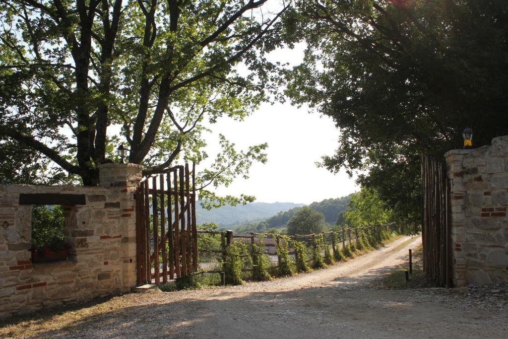 an iron gate on a dirt road with trees at La Tenuta - Resort Agricolo in Casaprota