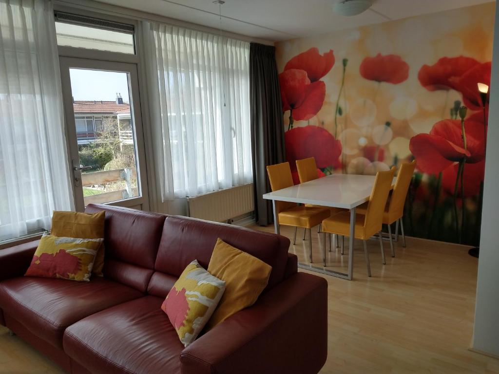 a living room with a couch and a table at KLAPROOS Bed by the Sea in Westkapelle