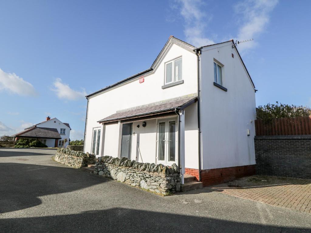 una casa blanca al lado de una calle en Bay View, en Holyhead