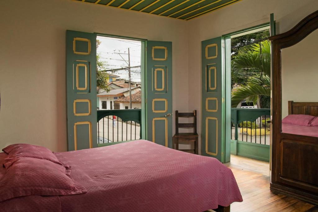 - une chambre avec un lit et une porte coulissante en verre dans l'établissement Hotel Calima, à Restrepo