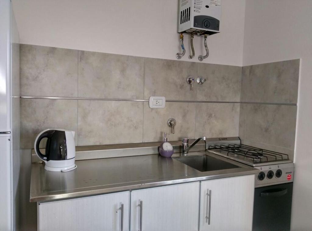 a kitchen with a sink and a stove at Aluminé in Colón