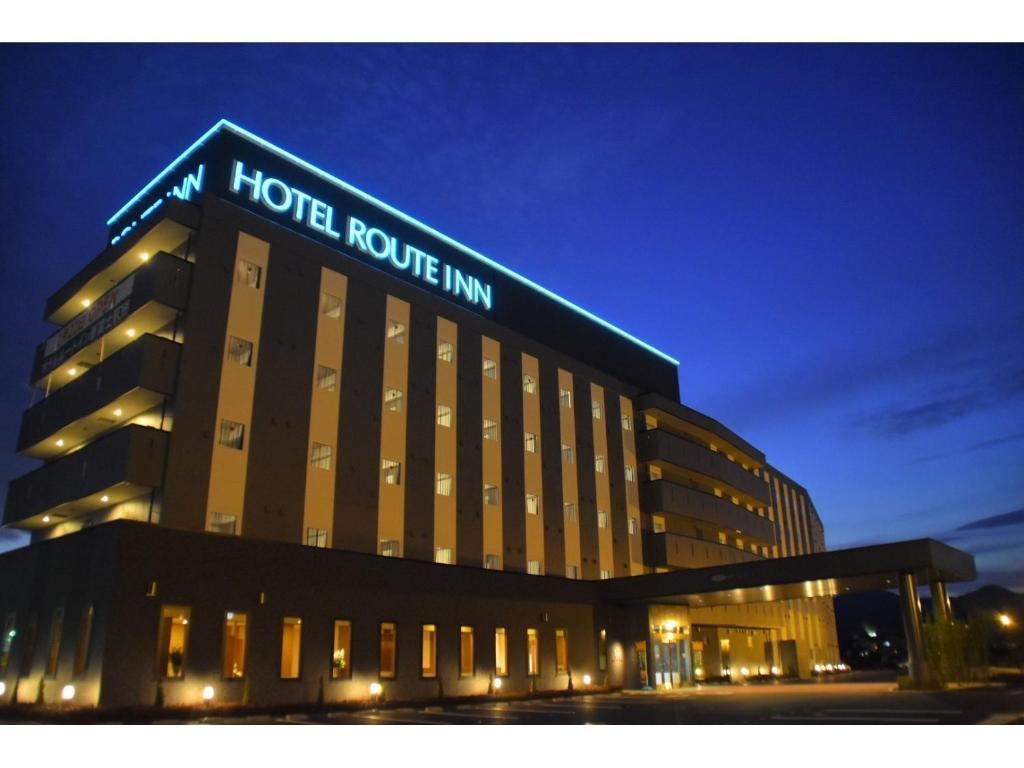 a hotel building with a sign on top of it at Hotel Route-Inn Shinfujieki Minami in Fuji