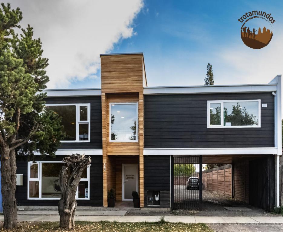 een huis met zwarte zijkanten en hout bij Trotamundos in Puerto Natales