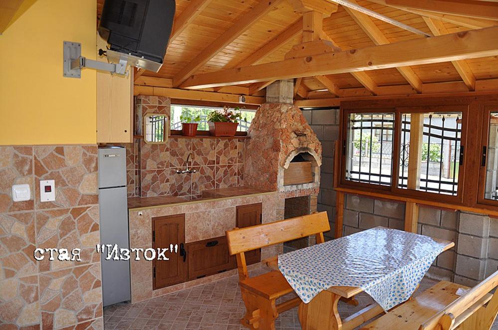 een keuken met een tafel en een stenen oven bij Лорета-Камен бряг in Kamen Bryag