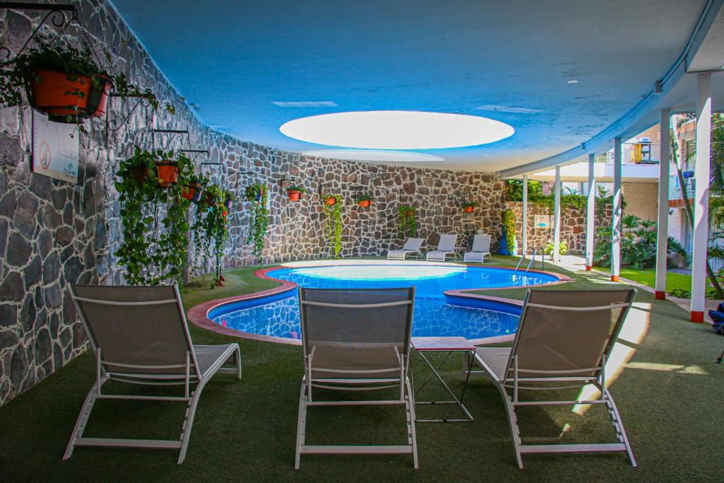 a room with a table and chairs and a swimming pool at Country Hotel & Suites in Guadalajara