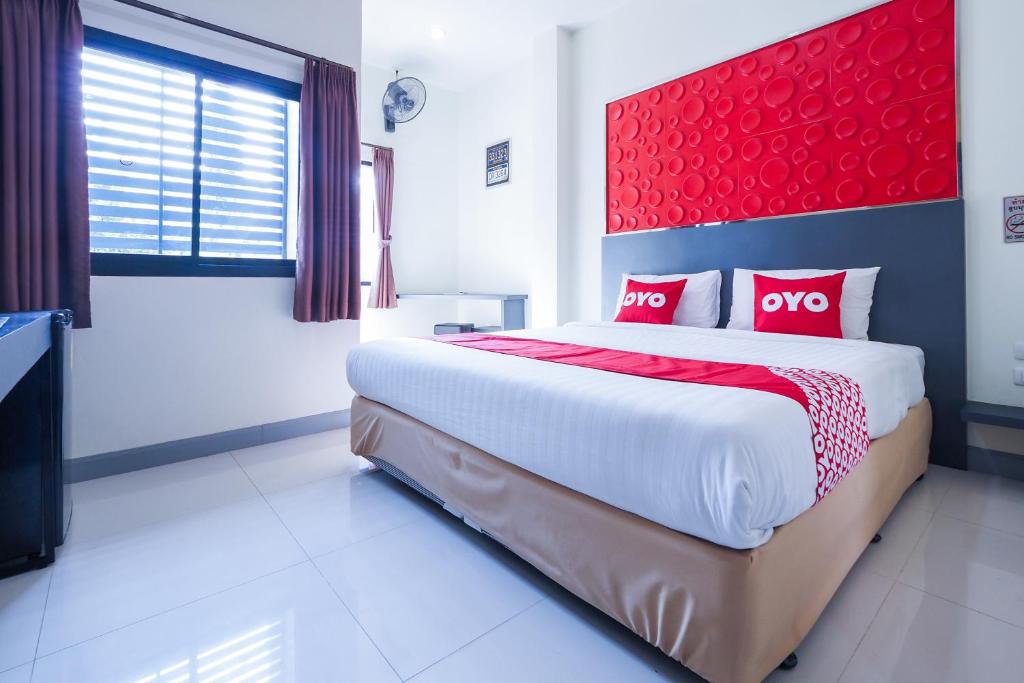 een slaapkamer met een groot bed met een rood hoofdeinde bij Korat Buri Green Hotel in Nakhon Ratchasima