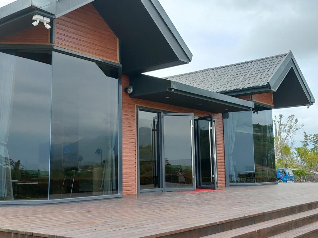 a building with glass doors and a wooden deck at Fu Yuan Tan Villa in Fuyuan