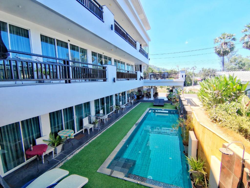 an external view of a hotel with a swimming pool at Amin Resort in Bang Tao Beach