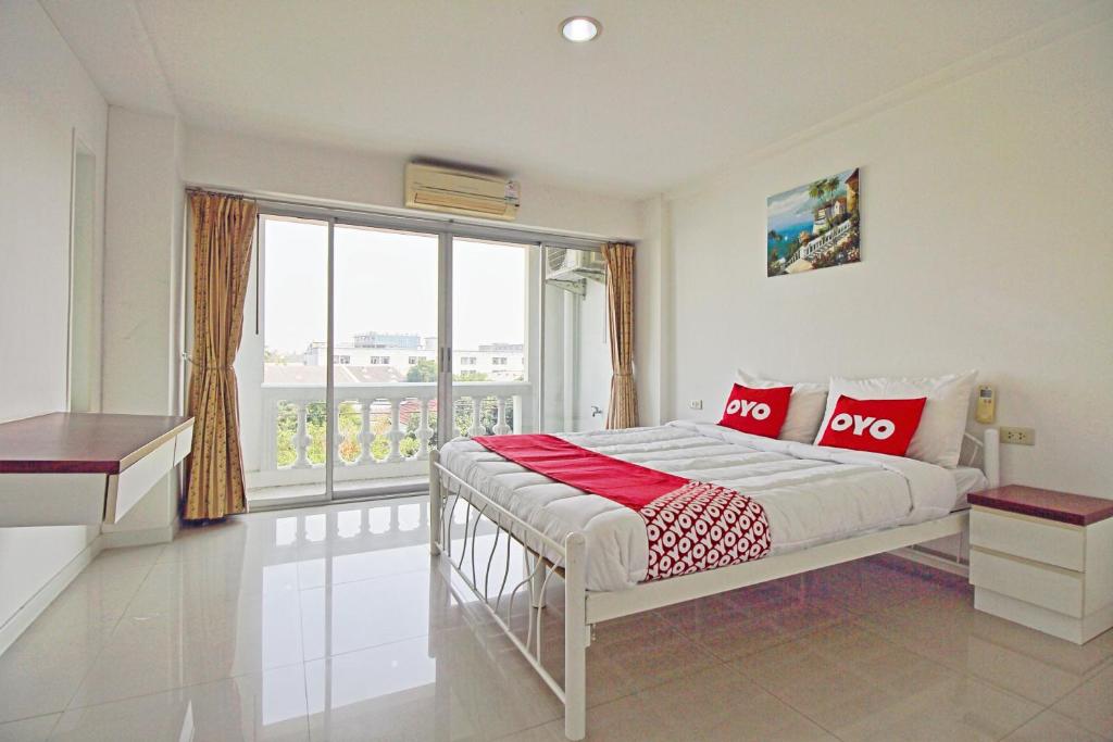 a bedroom with a bed and a large window at Super OYO 498 Ladawan Villa in Bangkok