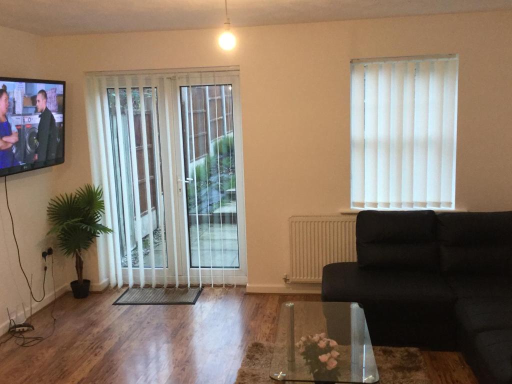 a living room with a couch and a glass table at Quiet Residential Area Within Easy Reach Of Town in Manchester