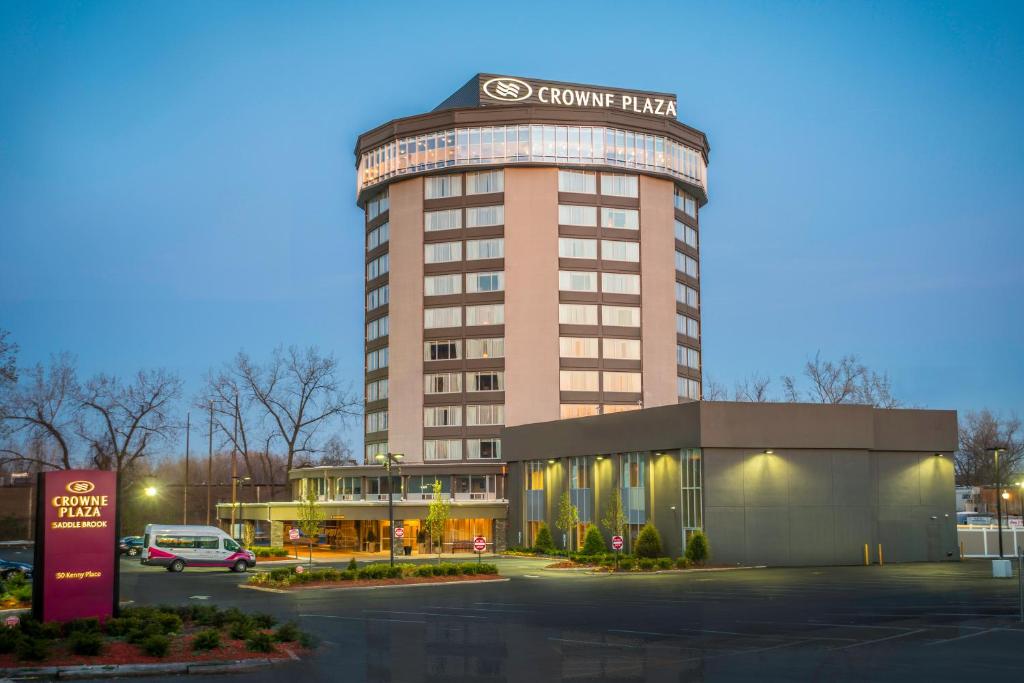 a building with a car parked in a parking lot at Crowne Plaza Saddle Brook, an IHG Hotel in Saddle Brook