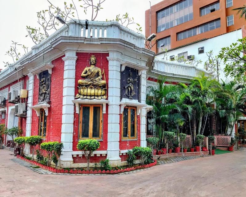 um edifício vermelho e branco com uma estátua em Heritage Hotel em Lucknow