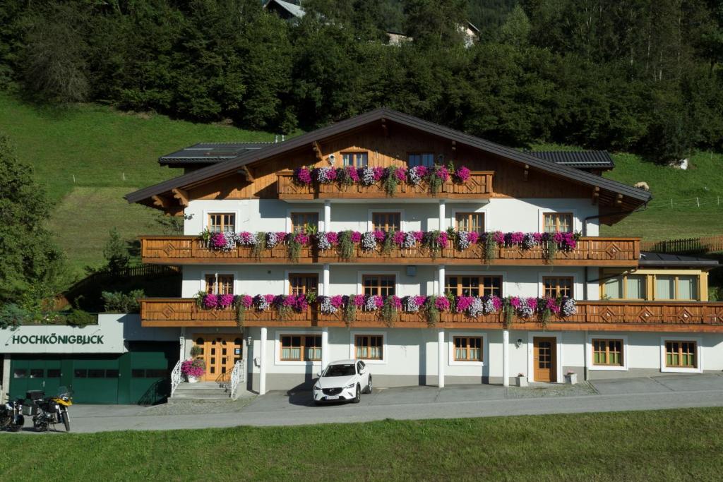 budynek z balkonem pokrytym kwiatami w obiekcie Pension Hochkönigblick w mieście Sankt Johann im Pongau