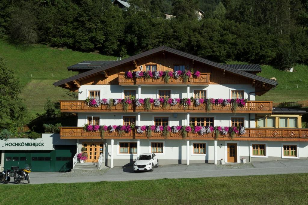 un edificio con un balcón con flores. en Pension Hochkönigblick, en Sankt Johann im Pongau