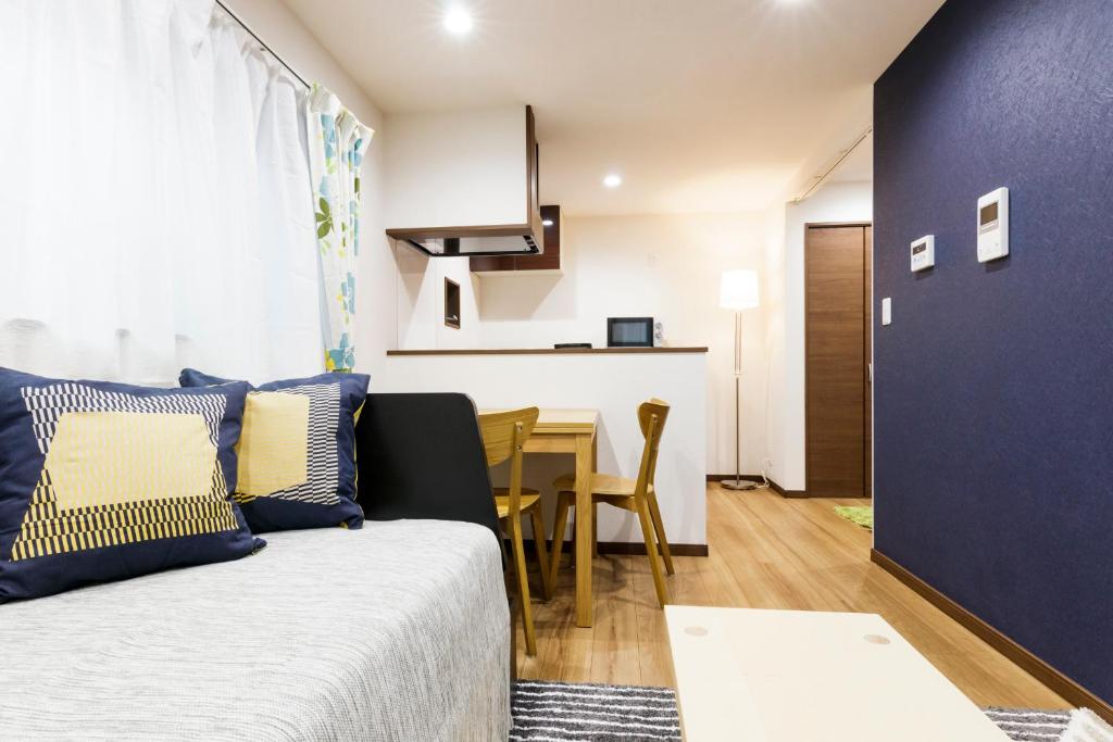een woonkamer met een bank en een tafel bij Crescent Moon Nakanoshimbashi in Tokyo