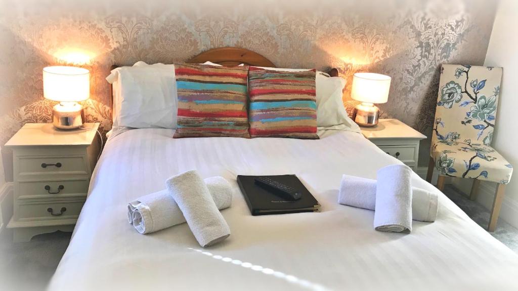 a bed with towels and a book on it at St. Raphael Guest House in York