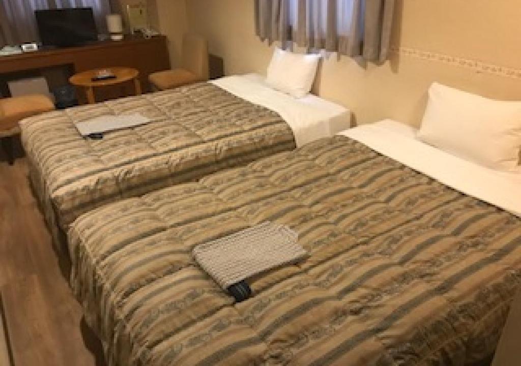 En eller flere senger på et rom på Business Hotel Goi Hills