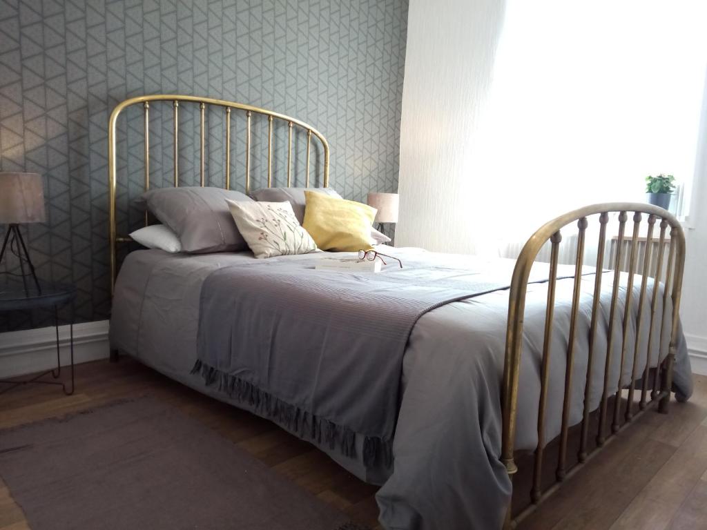 1 cama con marco de metal en un dormitorio en Les Sauges, en Isigny-sur-Mer