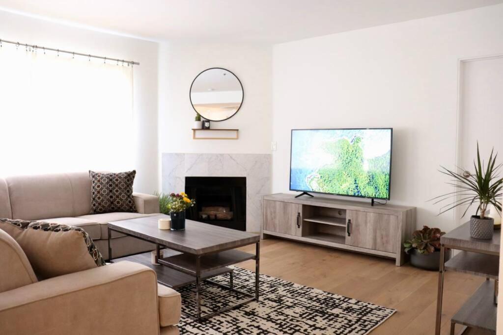 a living room with a couch and a tv at HEART OF WEST HOLLYWOOD MODERN SUITE 2 BEDROOM 2 BATH in Los Angeles