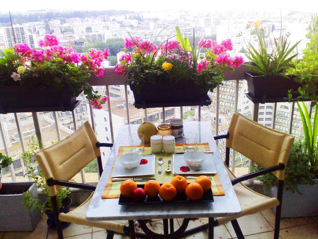 a table with oranges on it on a balcony with flowers at Paris On Top in Paris