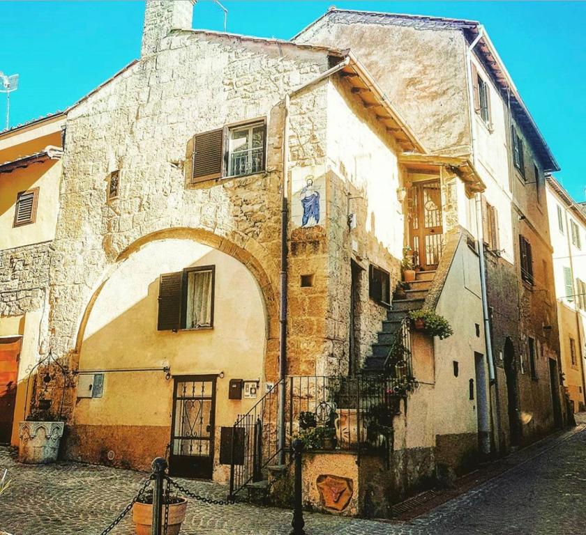 un antiguo edificio de piedra con un arco en una calle en Casetta di San Martino en Tarquinia