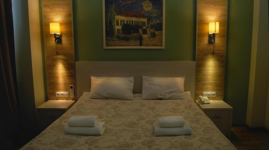 a bedroom with a bed with two pillows on it at Hotel Complex Kupecheskiy Dvor in Rostov on Don