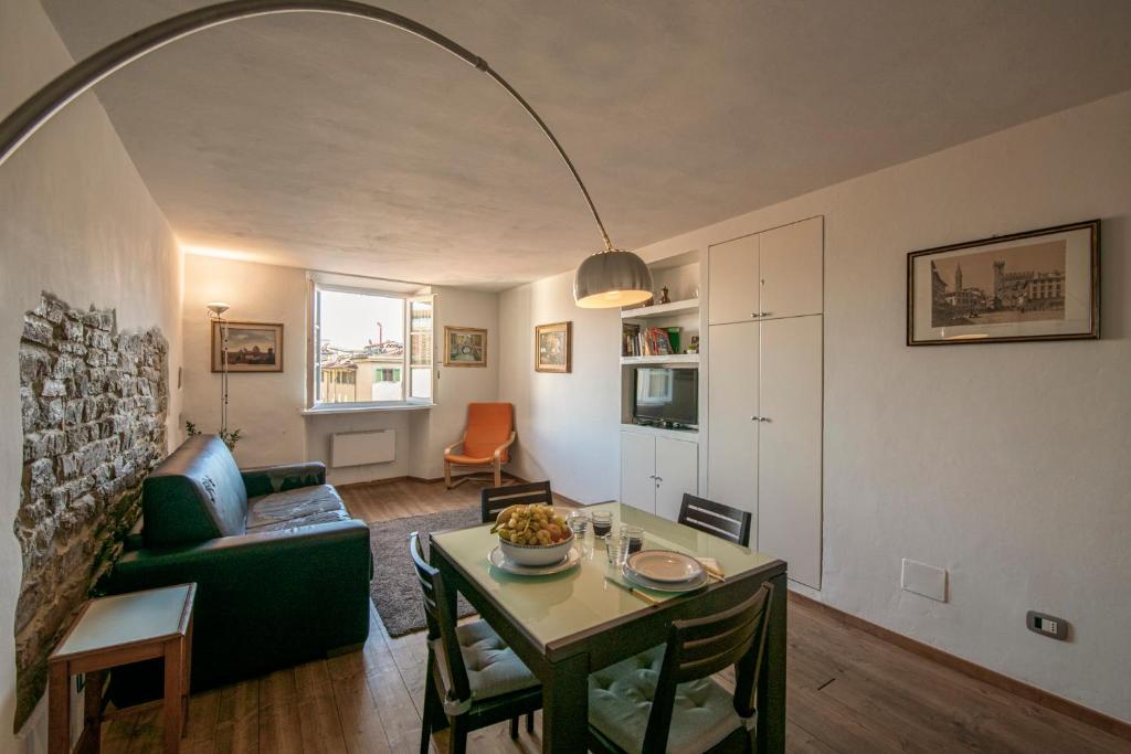un soggiorno con divano verde e tavolo di Mamo Florence - Proconsolo Bargello Apartment a Firenze