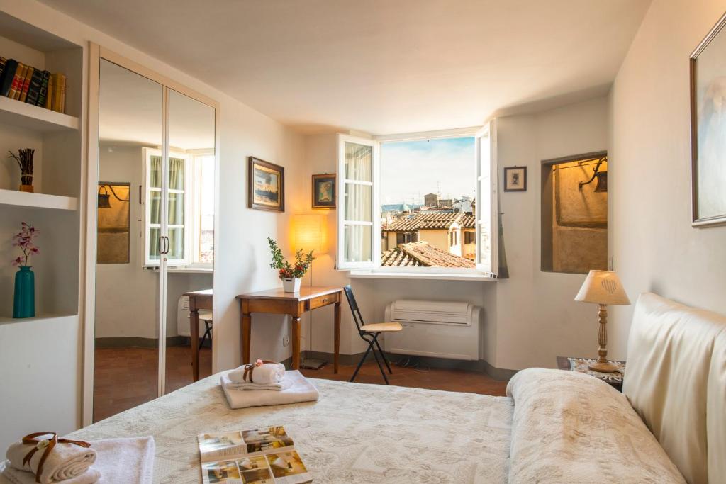 Una sala de estar con una cama y una ventana. en Proconsolo Bargello Apartment by Mamo Florence, en Florencia