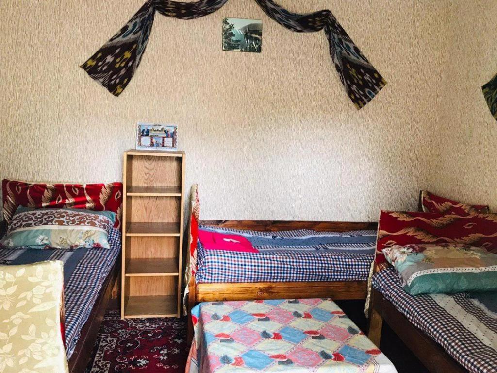 a room with two twin beds and a shelf at Гостевой Дом ''Мы у друзей'' Ходжа Калон in Bukhara