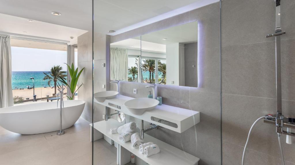 a bathroom with two sinks and a tub and a mirror at The Hype Beachhouse in Playa de Palma