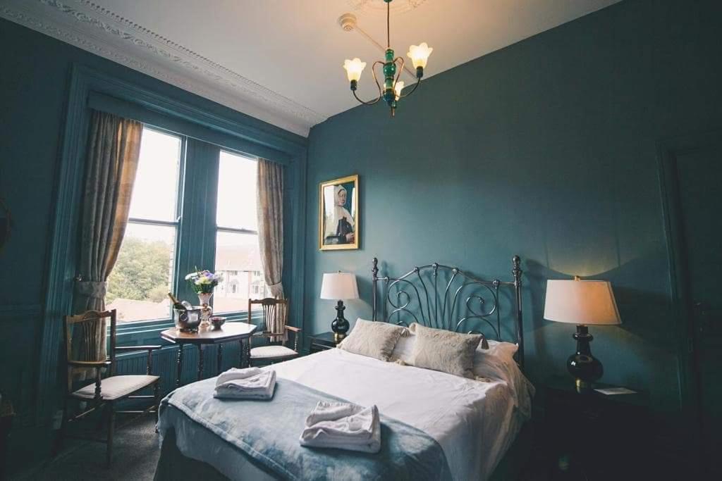 a bedroom with a bed with two towels on it at Glendale Hotel in Cardiff