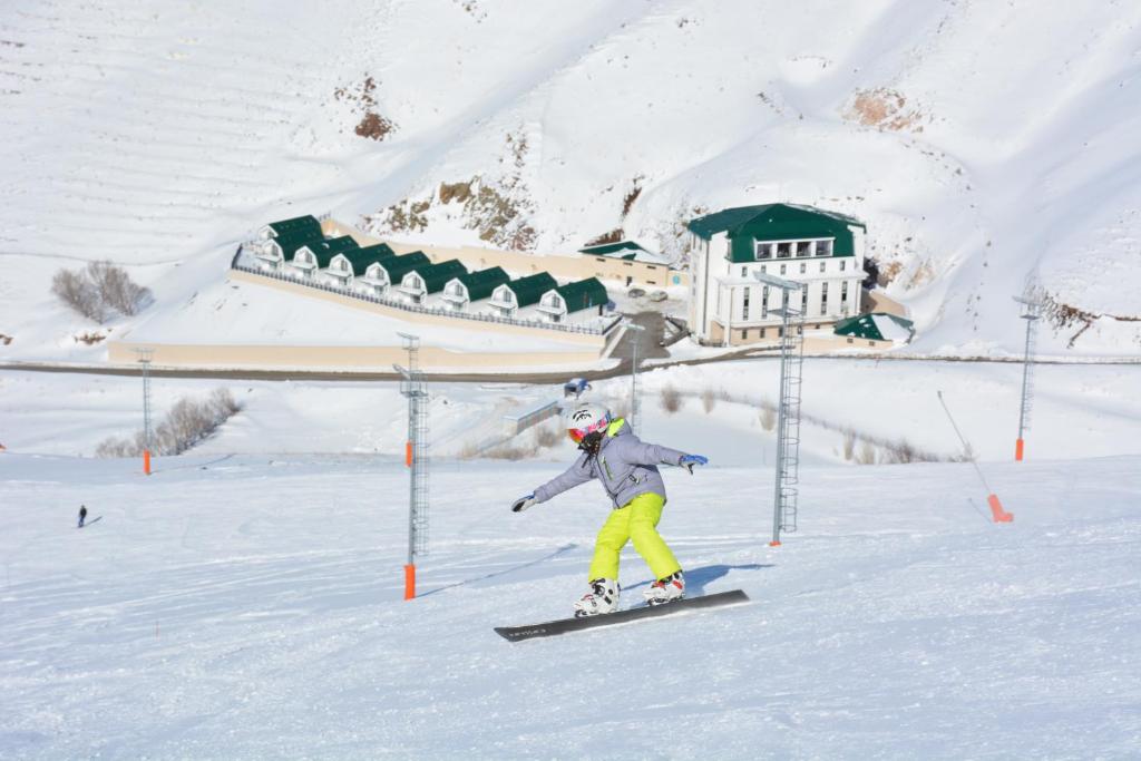 a person riding a snowboard down a snow covered slope at Ve Hotels Palandöken in Erzurum