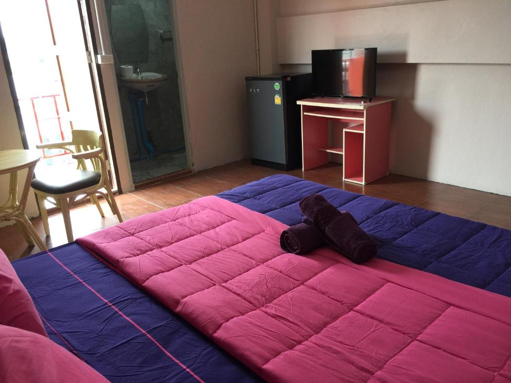 a large bed with a pink blanket in a room at SMILE HOME GUESTHOUSE in Rayong