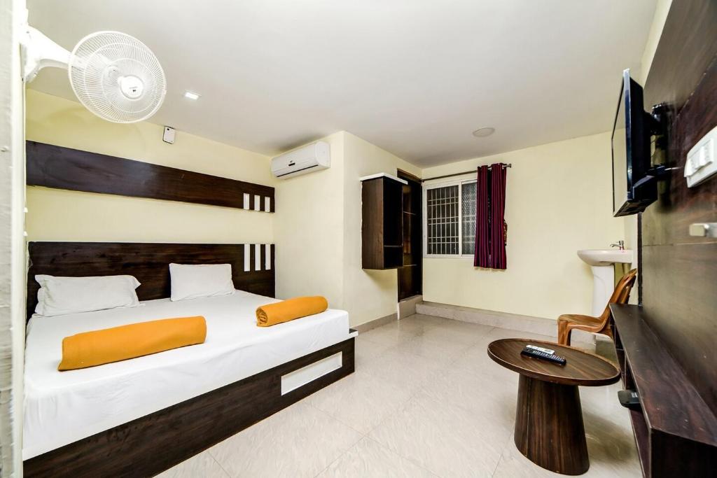 a bedroom with a bed and a tv and a table at Hotel Raj Inn Ajmer Sharif in Ajmer