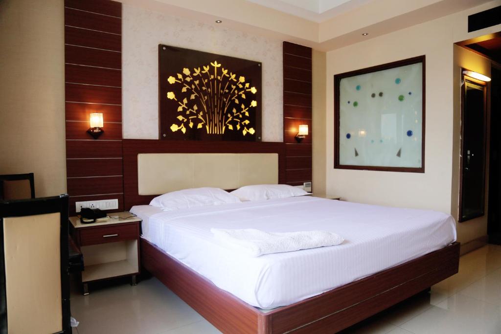 a bedroom with a large white bed in a room at Maya Residency in Tiruchchirāppalli