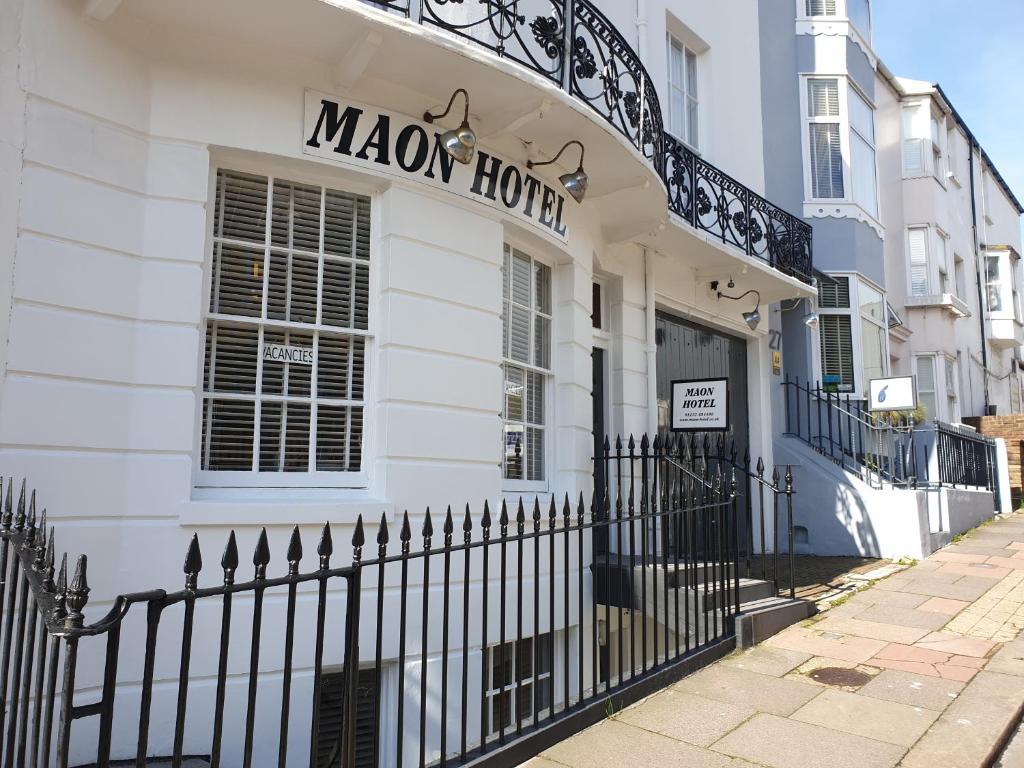 a white building with a black fence in front of it at Maon Hotel in Brighton & Hove