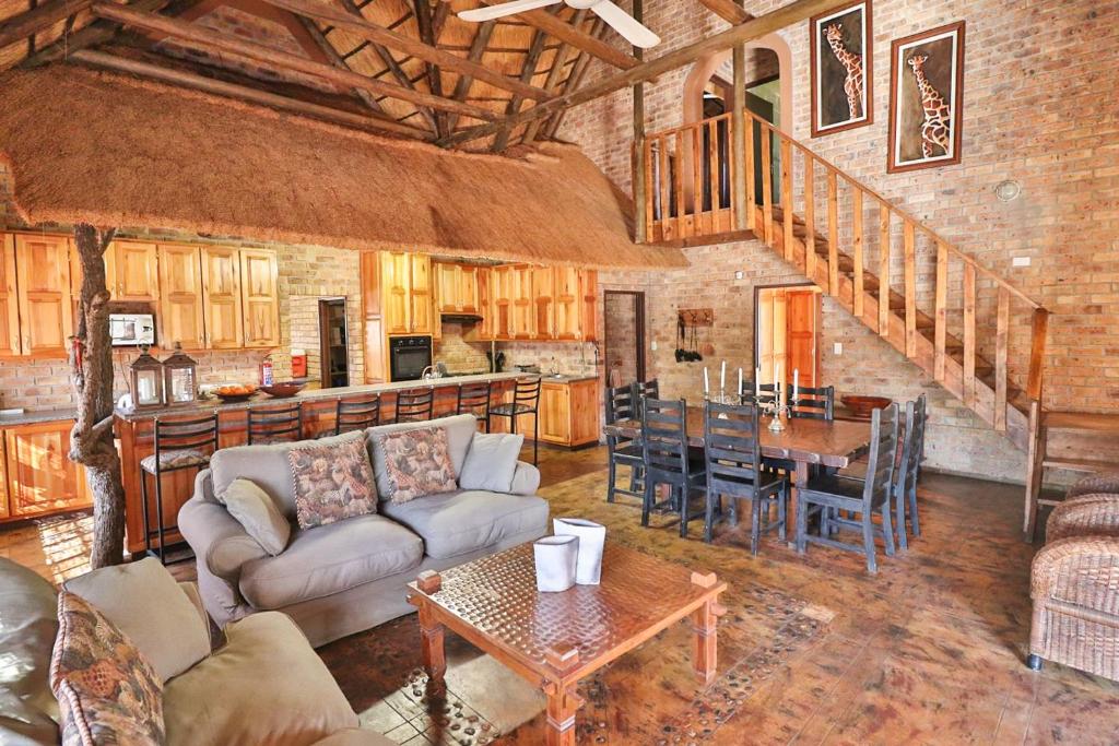 a living room with a couch and a table at Adventure Bush House in Marloth Park