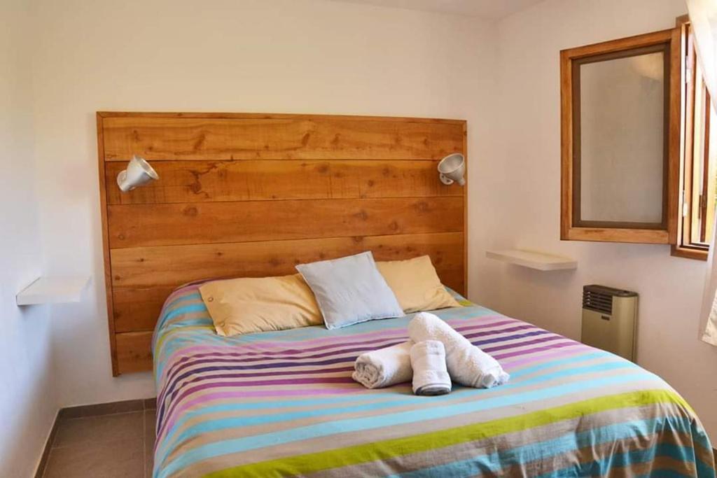 a bedroom with a bed with two towels on it at Hostel Planeta Cumbrecita in La Cumbrecita