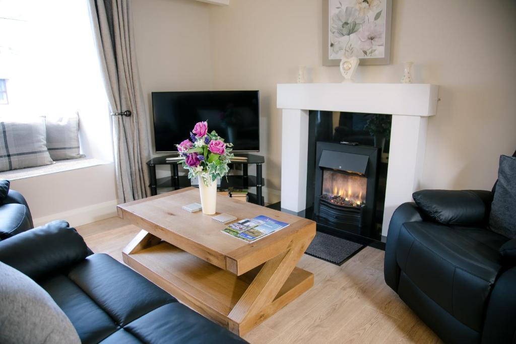 a living room with a coffee table and a fireplace at Eske Holiday Apartment in Donegal
